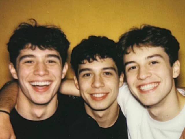 Three friends with their arms around each other at a party
