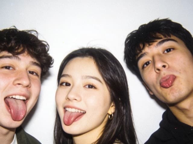 The same four friends, one throwing a peace sign